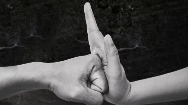 Faust und flache Hand treffen aufeinander